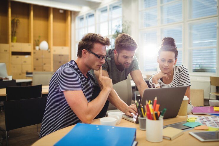 SEO Specialists collaborating in office, brainstorming ideas with computer