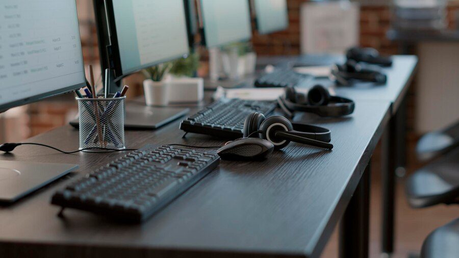 Contact center office with computers and headsets, enhancing customer experience and business success.