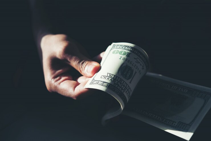 Close-up of hands counting dollar bills, representing cost savings through Florida outsourcing wage solution.