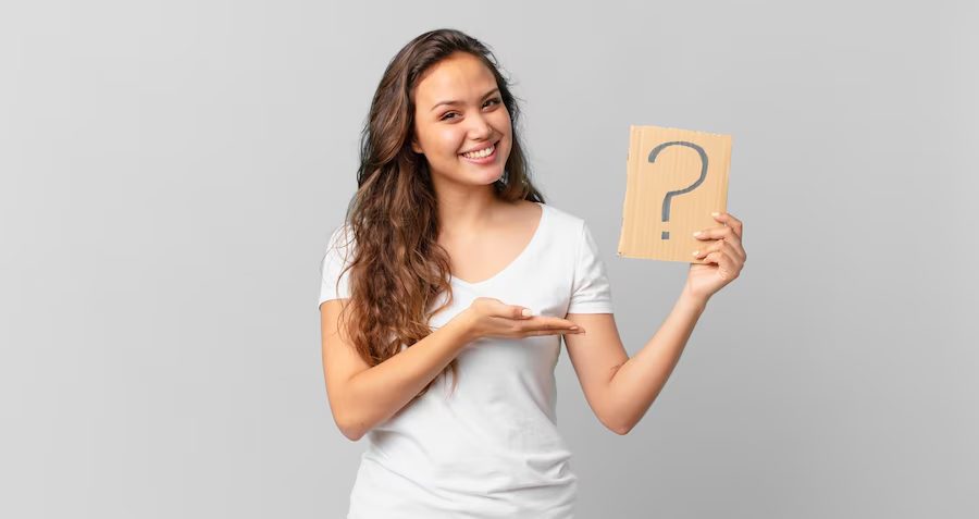 Gray background with a woman holding a paper displaying a question mark, symbolizing the definition of ROI in PPC campaigns