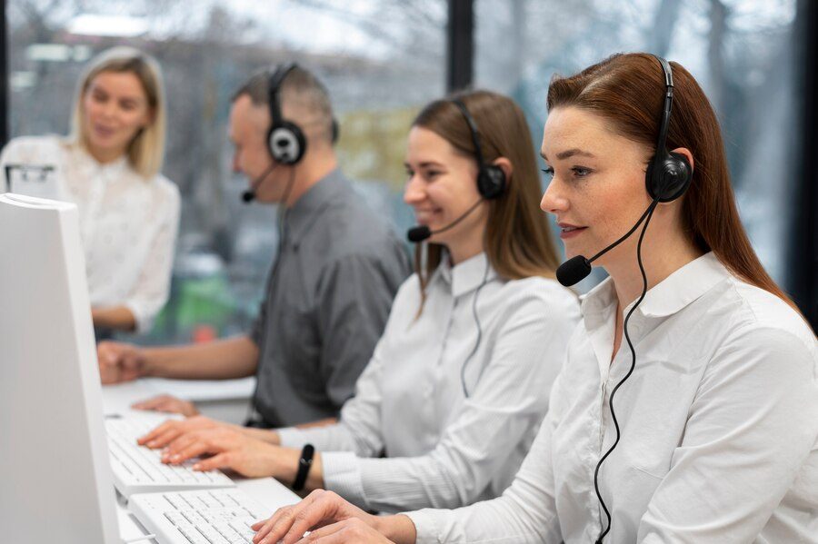 Contact center workers using specialized software to manage customer interactions and enhance satisfaction, illustrating effective customer service solutions.