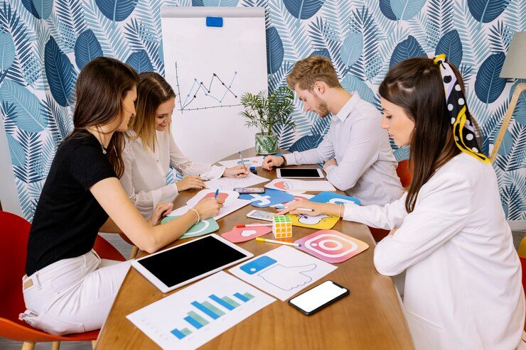 A group of people in an office working on business objectives for a Quarterly Strategy, analyzing a graph from a previous report.