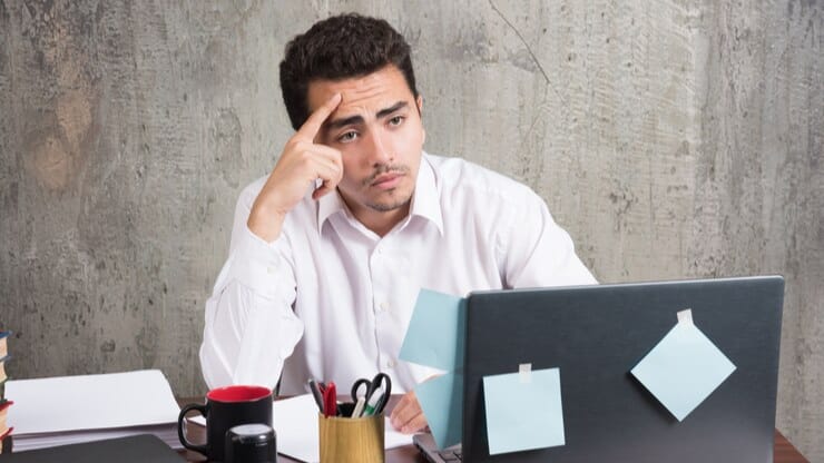 Frustrated man at his desk, symbolizing challenges of relying on outdated Instagram hashtag tactics.