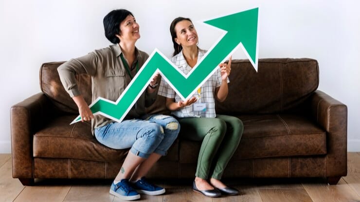 Two women holding an upward arrow symbol, illustrating growth in engagement with updated Instagram strategies.