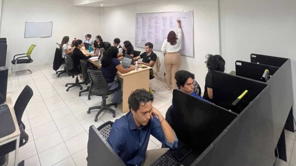 A collaborative marketing team in Nicaragua's outsourcing office, with professionals discussing strategies and working at desks.