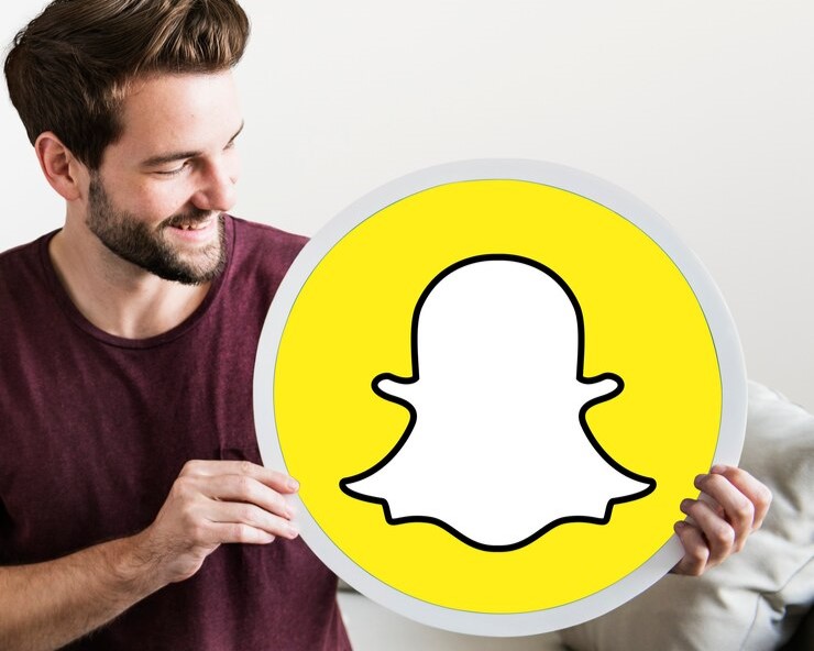 A person holding a Snapchat logo, representing Snapchat Spotlight as an alternative to TikTok for Gen Z engagement.
