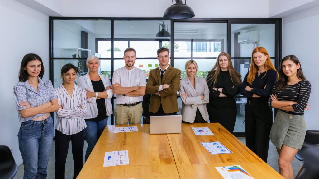 Confident marketing team standing around a meeting table, representing collaboration in content marketing strategy