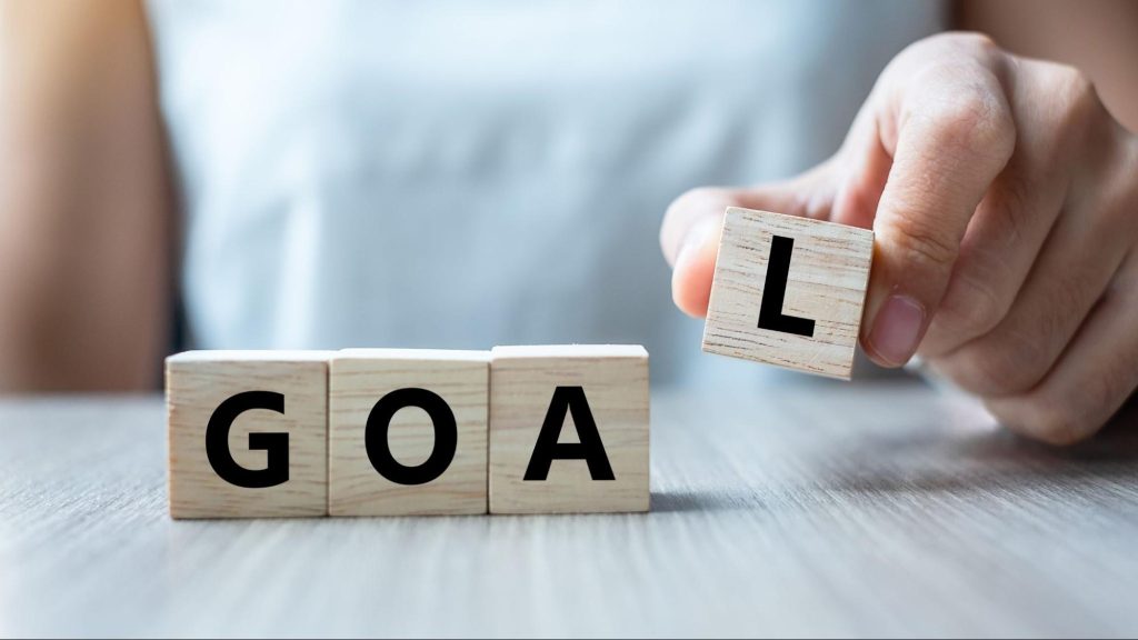 Wooden blocks spelling the word goal, symbolizing strategic goal setting for growth hacks for content marketing.