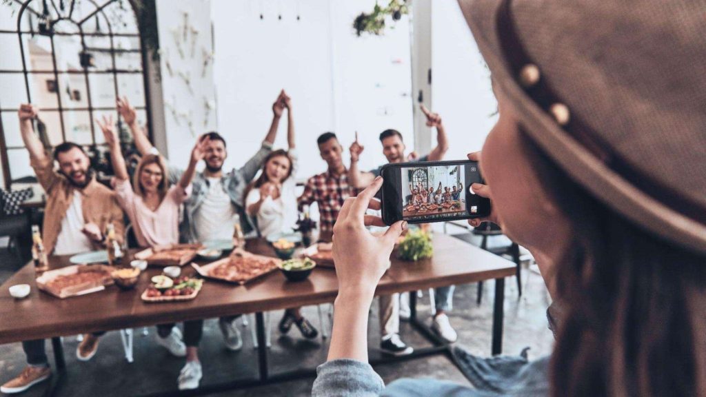 Woman capturing a group photo to illustrate influencer collaboration and community-building content.
